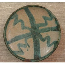 Green cross with rays on a clay plate, wavy cross